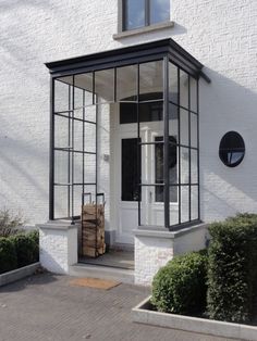 a white building with black trim and glass windows on the front door is seen in this image