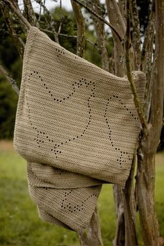 a crocheted bag hanging from a tree