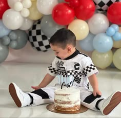 a young boy sitting in front of a cake