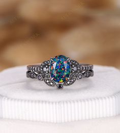 a white gold ring with an opal colored stone in the center