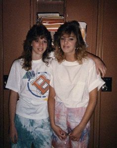 two young women standing next to each other in front of a locker with books on it