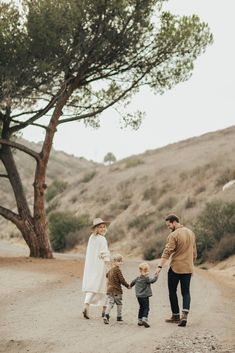 a family walking down a dirt road holding hands