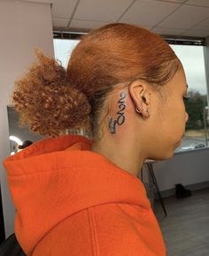 a woman with tattoos on her neck and behind her ear