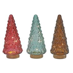 three different colored glass christmas trees on a white background