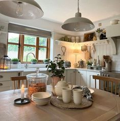 a kitchen table with dishes and cups on it