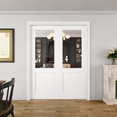 a dining room with white walls and wood flooring next to an open fire place