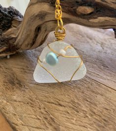 Beautiful handmade pendant.  Frosted white sea glass wrapped in gold and threaded with a baby blue freshwater pearl and 2 tiny white beads.  Gorgeous! Sea glass collected from England's east coast. Wear this beach treasure wherever you go!   It measures 20 x 30 mm.  Two choices of chain lengths. The pearl is for purity and simplicity.  A gift from nature.  Birthstone Gemini. Only one unique design. Makes an ideal gift for that person who likes something different.  Beautifully gift wrapped with Cable Jewelry, White Sea Glass, Gold Wrap, Sea Glass Pendant, White Sea, Wedding Jewellery Necklace, Pendant Gold, Handmade Pendant, White Beads