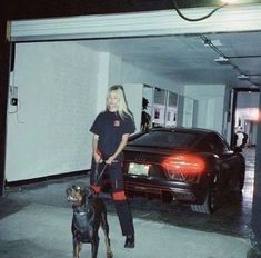 a woman standing next to a dog in a parking garage