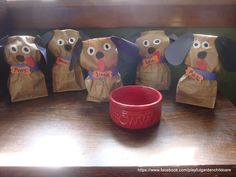 some paper bags with dogs on them and a red bowl in the middle sitting on a table