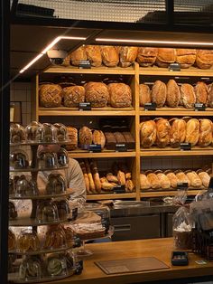 a bakery filled with lots of breads and pastries on display behind the counter