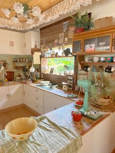 a kitchen filled with lots of clutter and dishes on top of a counter next to a window