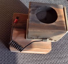 a wooden object with a black hole in the middle and wires coming out of it