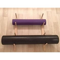 two yoga mats and one exercise mat are on the floor with pegs in front of them