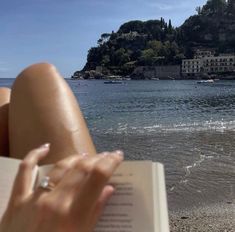 someone is reading a book on the beach