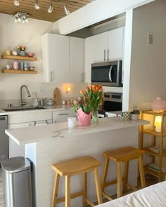 the kitchen is clean and ready to be used for cooking or eating, with two stools in front of the bar