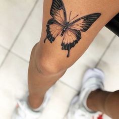 a woman's leg with a butterfly tattoo on it