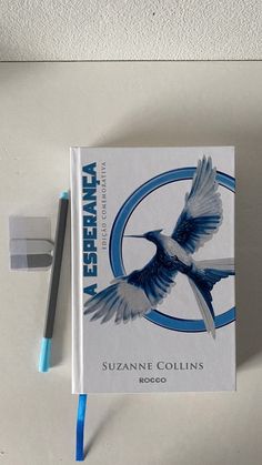 a book sitting on top of a white table next to a blue and black pen