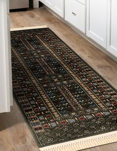 a kitchen area with a rug on the floor and white cabinets in the back ground