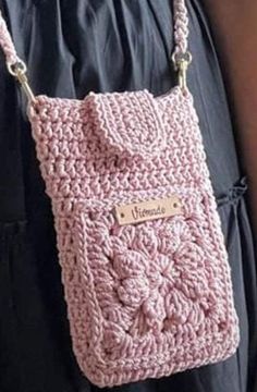 a pink crocheted purse hanging from the back of a woman's shoulder