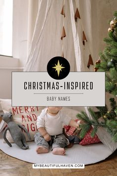 a baby sitting in front of a christmas tree with the words, christmas - inspired baby names