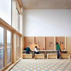 two people sitting on benches in the middle of a room with large windows and lots of light