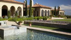 an outdoor fountain in front of a large house