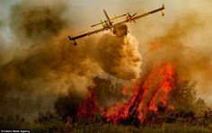 an airplane is flying over a fire