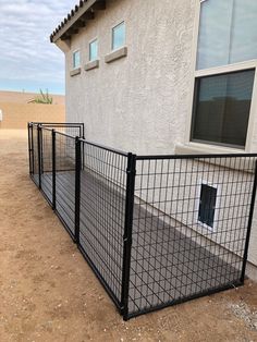 a black metal fence in front of a house with a dog door on the side