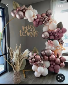 the balloon arch is decorated with pink, gold and white balloons