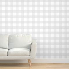 a white couch sitting in front of a pink checkered wall