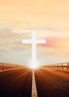 an empty road with a cross in the middle and sun shining down on it's horizon