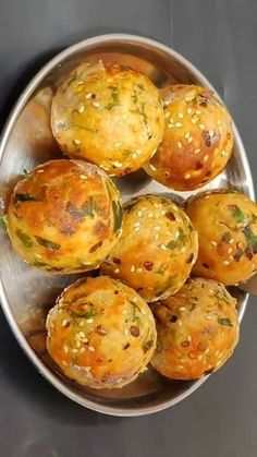 several muffins in a metal bowl on a table