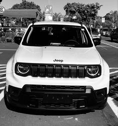 the jeep is parked on the side of the road in black and white, with people walking by