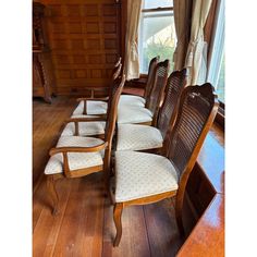 a row of chairs sitting on top of a hard wood floor next to a window