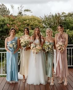 a group of women standing next to each other on a wooden floor covered in flowers