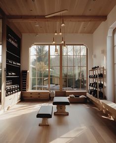 a large room with wooden floors and lots of windows on the wall, along with two benches