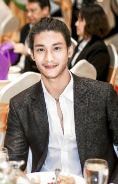 a young man sitting at a table in a restaurant