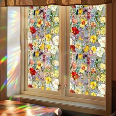 the sun shines through two stained glass windows with flowers on them in front of a window sill