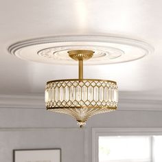 a chandelier hanging from the ceiling in a room with white walls and windows