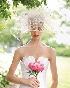 a woman in a white dress holding a pink flower