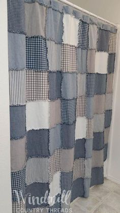 a blue and white checkered shower curtain hanging in a bathroom with tile flooring