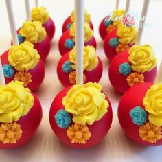 red cake pops decorated with yellow and blue flowers