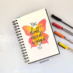 a note book with pens and markers next to it that says, you don't need wings