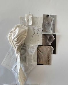 several pieces of paper are arranged on the wall with clothes hanging from it's sides