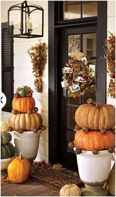 pumpkins and gourds are stacked on top of each other in front of a door