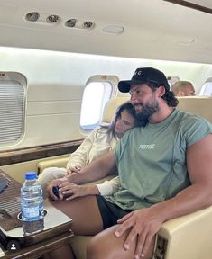 a man and woman are sitting on an airplane