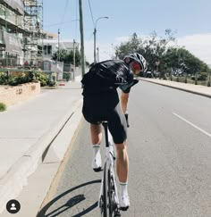 a man riding a bike down the middle of a street