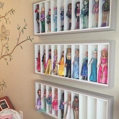 there are three shelves with barbie dolls in them on the wall next to a bed