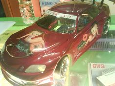 a red car with an advertisement on the front and back window sitting on display in a store