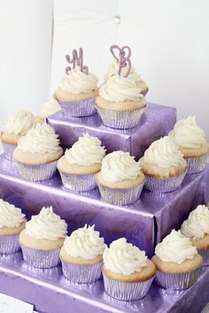 there are many cupcakes on the purple cake stand